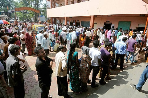 People wait in queues to cast votes for Assembly polls at a polling station in Mumbai on Wednesday | PTI