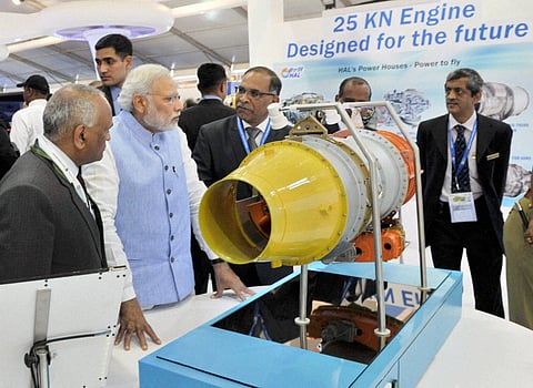 Prime Minister Narendra Modi visits a stall after the inauguration of the Aero India 2015 event at Yelhanka Air Base in Bengaluru on Wednesday. (PTI)