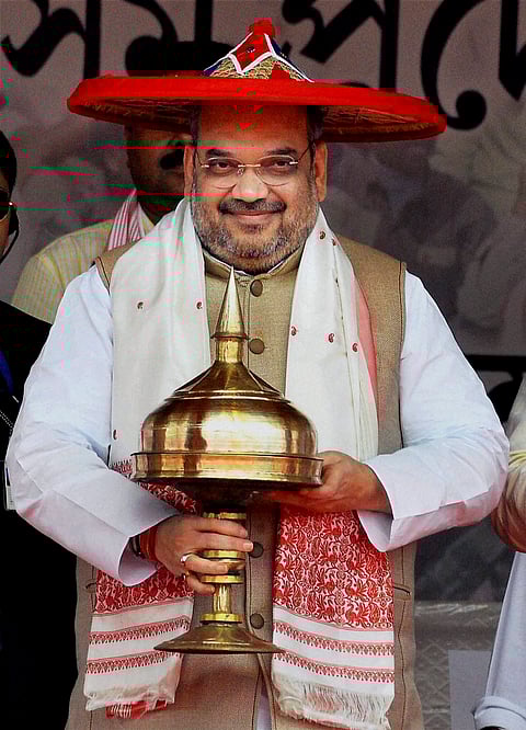 Caption: Guwahati BJP National President Amit Shah being felicitated with an Assamese Japi and Khoria during the BJP Janajagaran Samaroah at Khanapara in Guwahati on Sunday.