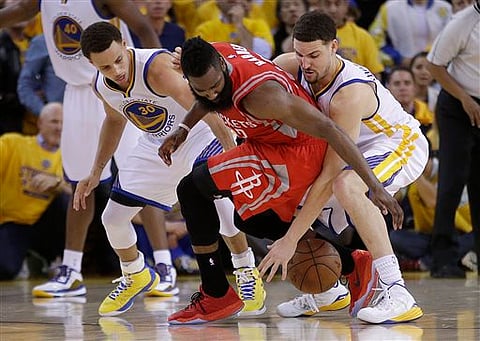 Houston Rockets guard James Harden, center, loses the ball on the game's final play as he Golden State Warriors guards Stephen Curry, left, and Klay Thompson defend during the second half of Game 2 of the NBA basketball Western Conference finals in Oakla