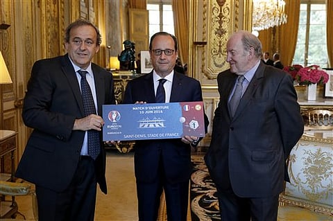 European Soccer Federation UEFA President Michel Platini, left, and UEFA EURO 2016 SAS chairman Jacques Lambert, right, present a facsimile of an Euro 2016 ticket to French President Francois Hollande during a meeting at the Elysee Palace in Paris, France