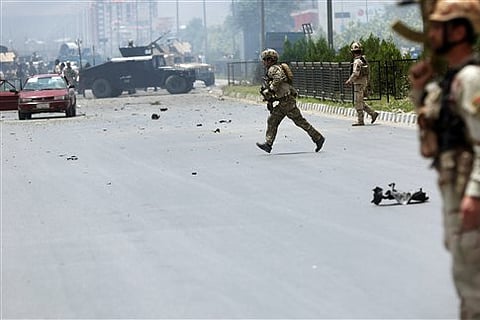 Afghan security forces run at the site of a suicide attack during clashes with Taliban fighters in front of the Parliament, in Kabul, Afghanistan. |AP