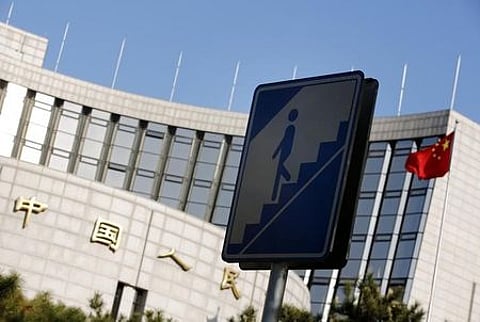 A sign for pedestrians is seen in front of the headquarters of the People's Bank of China, China's central bank, in central Beijing. | Reuters