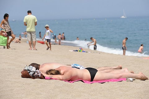 People enjoy swimming and sunbathing on a beach at Argeles-sur-Mer, on the Mediterranean Sea. (AFP)
