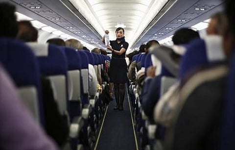 An Indigo Airlines' cabin crew member goes over safety guidelines during a flight.