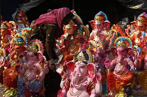 A woman displays idols of elephant headed Hindu god Ganesha, for the sale ahead of Ganesh Chaturthi festival in Jammu, India | AP