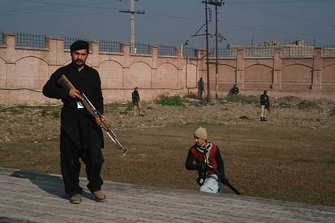 This photograph taken from a mobile phone shows Pakistani security personnel taking position outside the Bacha Khan university following an attack by gunmen in Charsadda, about 50 kilometres from Peshawar, on January 20, 2016. Gunmen have attacked a unive