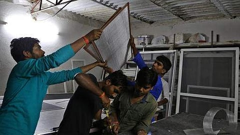 Indian workers at a Bangalore factory make mesh frames for windows used to keep mosquitoes out of homes