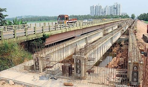 Installation of girders is under way at the proposed bridge at Akkulam. The old bridge is also seen B P Deepu