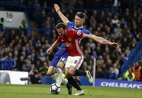 Chelsea’s Gary Cahill, left, and Manchester United’s Juan Mata challenge for the ball during the English Premier League soccer match. | AP