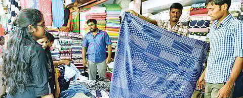 Shopkeepers sell their fabrics at Cotton Street