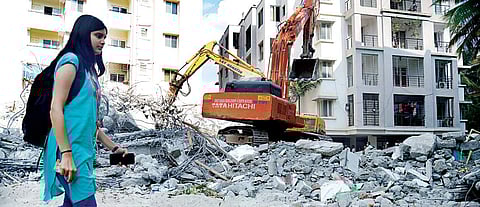 A girl walks by as Fire and Emergency services along with NDRF personnel clear debris at Bellandur after an under-construction building collapsed on Wednesday | Pushkar V