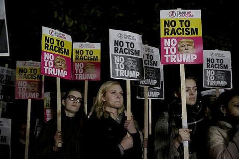 People hold placards as they take part in an anti-racism protest against Donald Trump winning the American election outside the U.S. embassy in London. (Photo | AP)