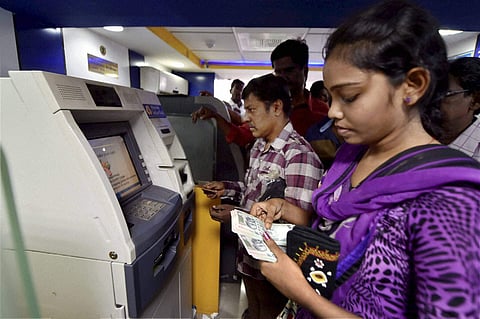 People queue up outside an ATM to withdraw money in Chennai on Friday. | PTI