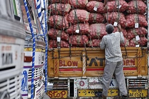 A labourer prepares to unload sacks of potatoes from a truck at a wholesale vegetable and fruit market. | Reuters