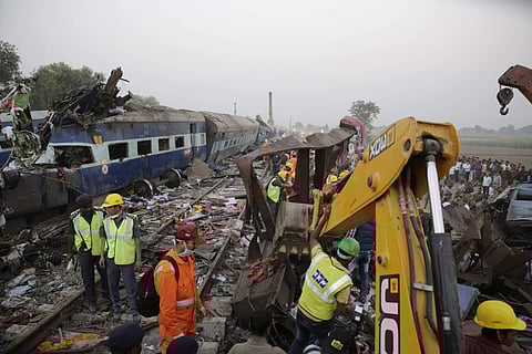 Rescuers use machinery to remove debris after 14 coaches of an overnight passenger train rolled off the track near Pukhrayan village Kanpur Dehat district, Uttar Pradesh. | AP