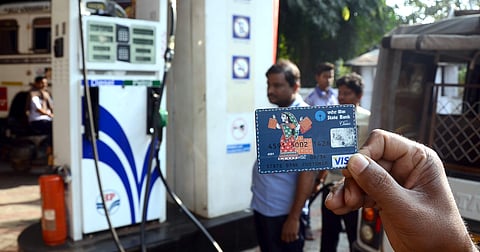 A man shows his SBI debit card at the petrol pump in front of Ram Mandir in Bhubaneswar on Monday| Express
