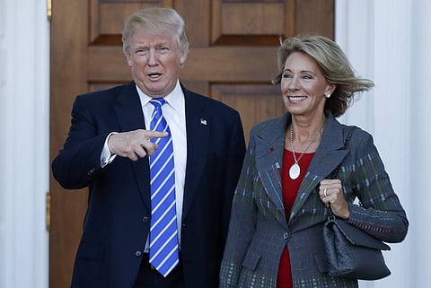 President-elect Donald Trump and Betsy DeVos pose for photographs at Trump National Golf Club Bedminster clubhouse in Bedminster, N.J. | AP