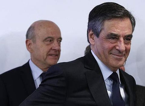Alain Juppe, left behind, watches Francois Fillon leaving after the conservative presidential primary in Paris. (AP)