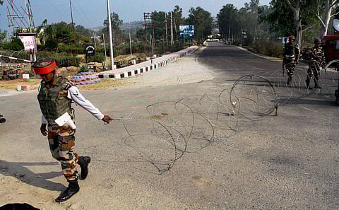 Army personnel close the road for civil vehicles with a barb-wire fence at 16 Corps headquarters during the search operations following Nagrota Army camp attack in Jammu on Wednesday. | PTI