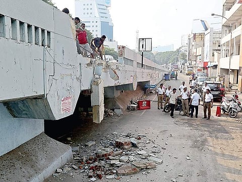 Workers removing the broken parts of the flyover wall (above), which a lorry (right) drove through in the wee hours of Tuesday | Romani Agarwal