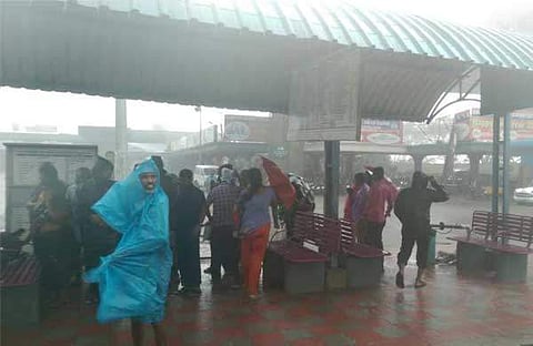 Passengers wait at the CMBT bus terminus as cyclone Vardah touches Chennai city. (John Abraham | Online desk)