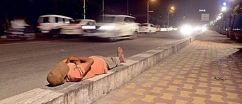 A homeless man sleeping on pavement. (EPS | R Satish Kumar)