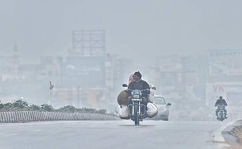 A man braving the chilly winds accompanied by light drizzle on the outskirts of Hyderabad on Wednesday | Vinay Madapu