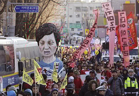 Protesters carry an effigy of impeached South Korean President Park Geun-hye as they march toward the presidential house during a rally in Seoul Saturday, Dec. 10, 2016. | AP