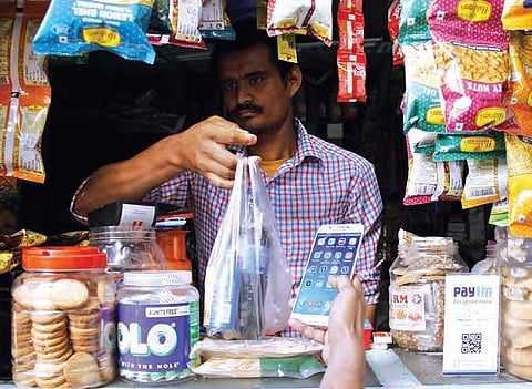 A shopkeeper accepting payment through the mobile wallet app in Hyderabad on Sunday | Sathya Keerthi