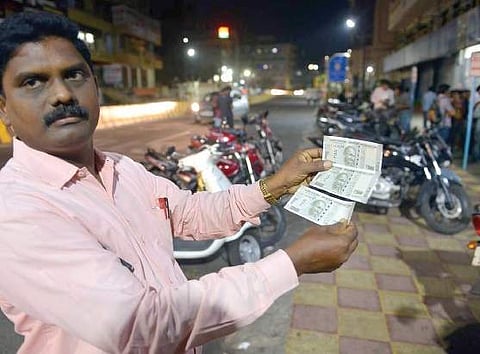 A customer showing the new D500 notes near an SBI ATM on Jail Road in Vizag, on Thursday