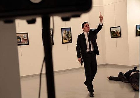The gunman gestures near Andrei Karlov, the Russian Ambassador to Turkey, after the latter was fatally shot at a photo gallery in Ankara | AP