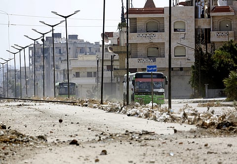 In this Sept. 22, 2016 file photo, Syrian government buses evacuate residents from Al-Waer, the last rebel-held neighborhood of Homs, Syria. | AP