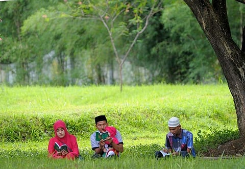 Family members gather to pray for their loved ones at a mass grave in Aceh on December 26, 2016, to mark the tsunami which devastated Aceh province 12 years ago in one of the worst natural disasters in human history. | AFP