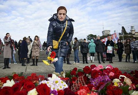 A woman puts flowers at a pier in Sochi, Russia, Monday, Dec. 26, 2016. | AP