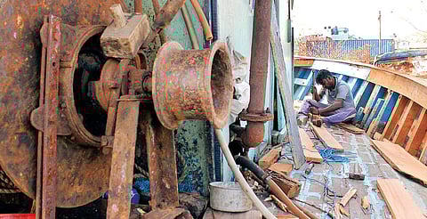 Fisherfolks repairing a boat, damaged during the cyclone at the Kasimedu fishing harbour in Chennai on Wednesday. | EPS
