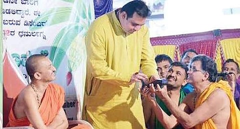 Minister Pramod Madhwaraj swiping his debit card to donate for Sri Palimaru Mutt on the occasion of ‘Baale Muhurtha’ ritual on Sunday