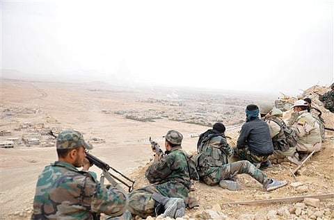 Syrian soldiers take up positions during fighting between Government forces and Islamic State group militants.