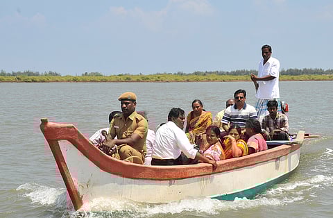 District collector S Palanisamy commuting through a boat to inspect the Kodiyampalayam polling booth in Nagapattinam district on Sunday. |EPS