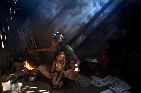 An elderly Indian woman cooks using firewood at her home at Gobhali village on the outskirts of Gauhati. |AP
