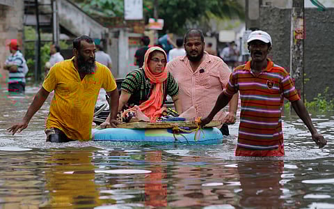 An elderly Sri Lankan woman is shifted on a makeshift raft at a flooded area in Colombo, Sri Lanka. (AP)