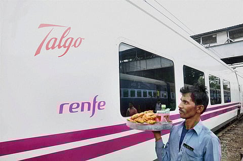 A vendor walks near the Spanish train Talgo after it arrives at Moradabad Railway Station during its first trial run between Bareilly and Moradabd on Sunday. | PTI