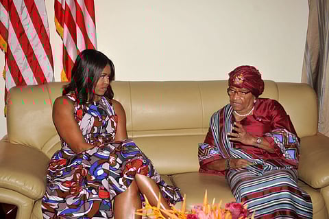 U.S. First lady Michelle Obama, left, listens to Liberian President Ellen Johnson Sirleaf, right, after she arrived at the airport in Monrovia, Liberia, Monday, June. 27, 2016. | AP