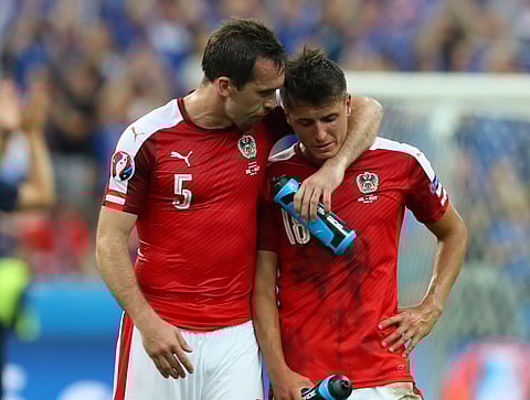 Austria's Christian Fuchs, left, tries to console his teammate, Alessandro Schoepf, at the end of the Euro 2016 Group F soccer match between Iceland and Austria at the Stade de France in Saint-Denis, north of Paris, France, Wednesday, June 22, 2016. | AP