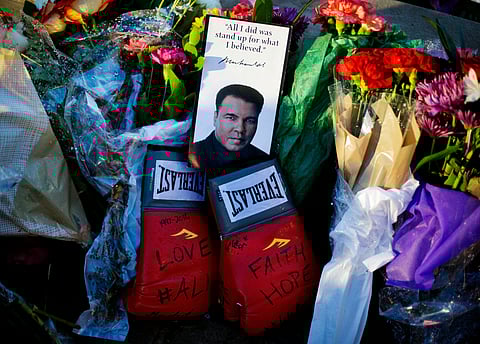 Boxing gloves and a message sit among flowers at a makeshift memorial to Muhammad Ali at the Muhammad Ali Center. |AP