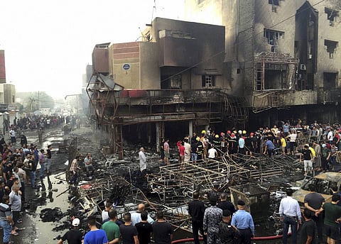 Iraqi security forces look for victims as civilians gather at the site after a car bomb at a commercial area in Karada neighborhood, Baghdad, Iraq, Sunday, July 3, 2016. | AP