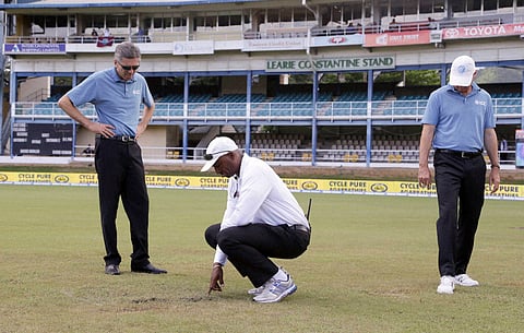 Umpires Nigel Llong left Gregory Brathwaite center and Rod Tucker inspect the field as a wet ground delays the start of day three of the fourth cricket Test match between India and West Indies at Queen's Park Oval in Port-of-Spain Trinidad. | AP