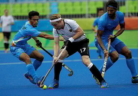 Germany's Christopher Rhur center fight for the ball against India's Kothajit Khadangbam left and India's Rupinder Pal Singh right during a men's field hockey match at 2016 Summer Olympics in Rio de Janeiro Brazil Monday Aug. 8 2016. | AP