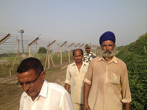 A group of Indian farmers are escorted to their fields on the Indo-Pakistan border by a soldier of the Border Security Force. I (Vikram Sharma | EPS)
