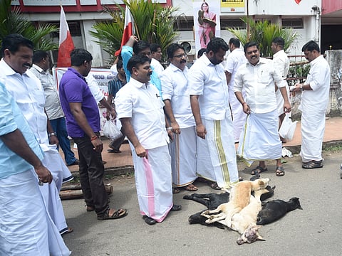 Youth Front (M) activists protesting with the carcasses of stray dogs in front of Head Post office in Kottayam on Monday. (Rajeev Prasad | EPS)